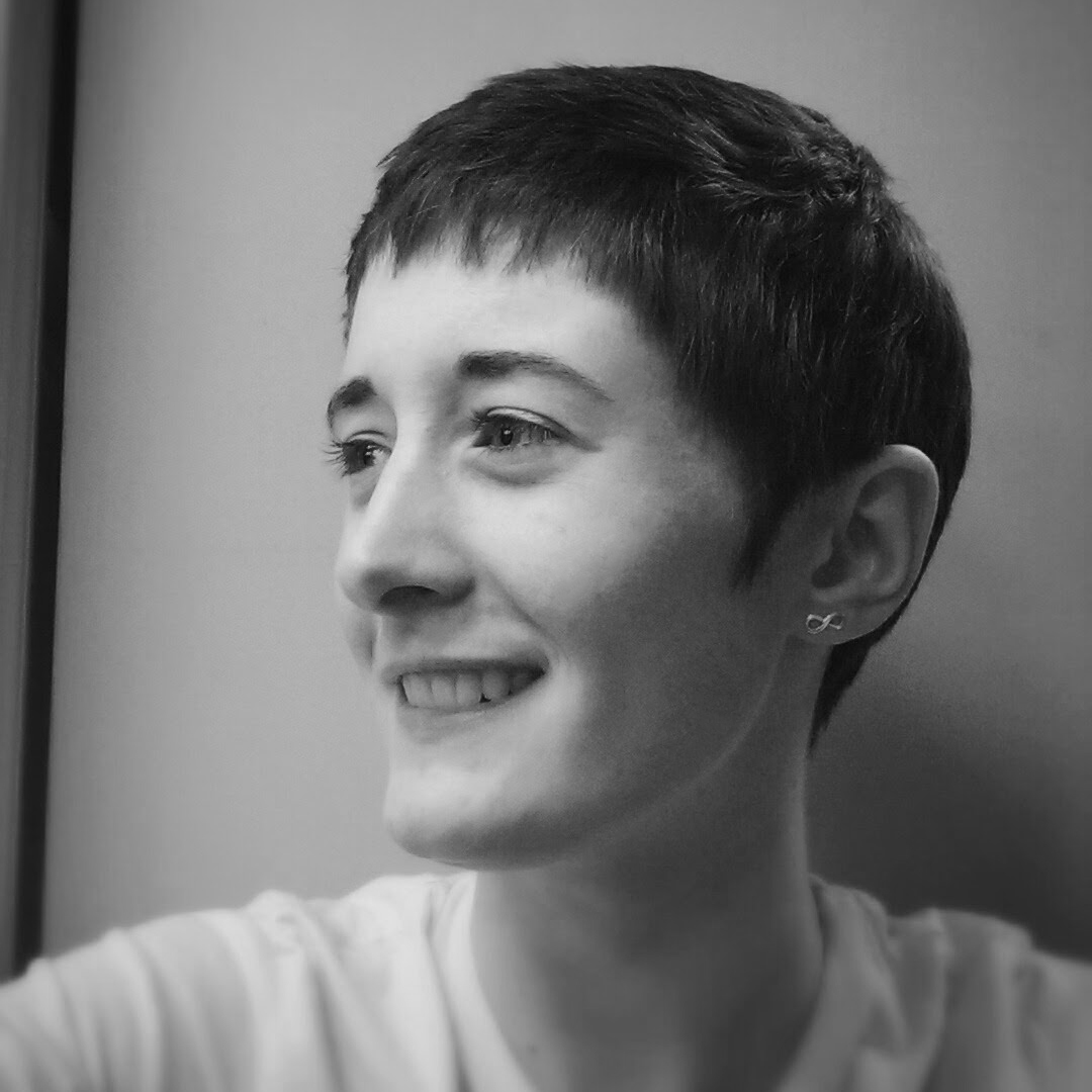 A headshot of a white woman with short, dark hair.